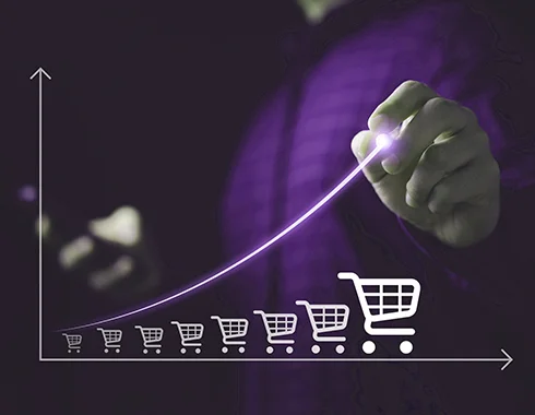 Hand drawing an upward growth curve with shopping cart icons, representing the transformation of telecom billing through business rules engine software.